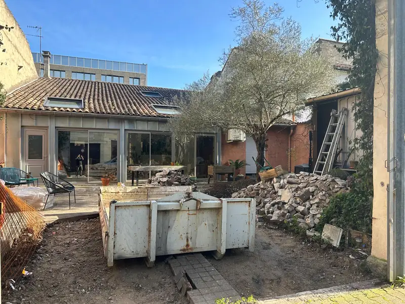 Benne de 8 m³ dans une cour pendant des travaux de rénovation