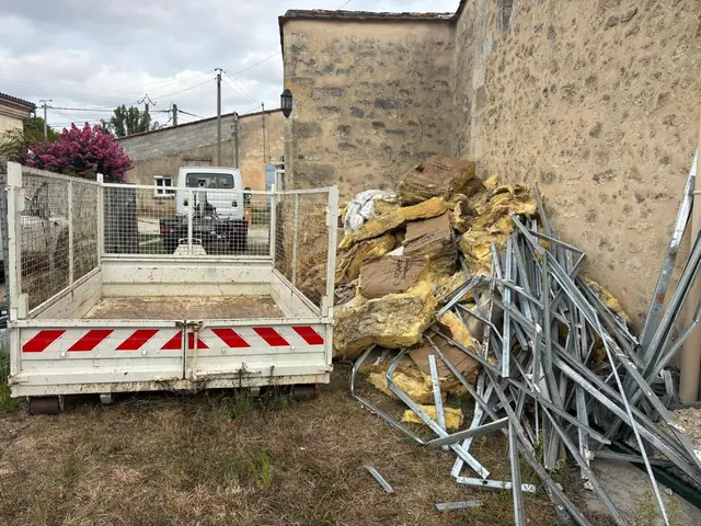 Benne et tas de laine de verre avec rails métalliques